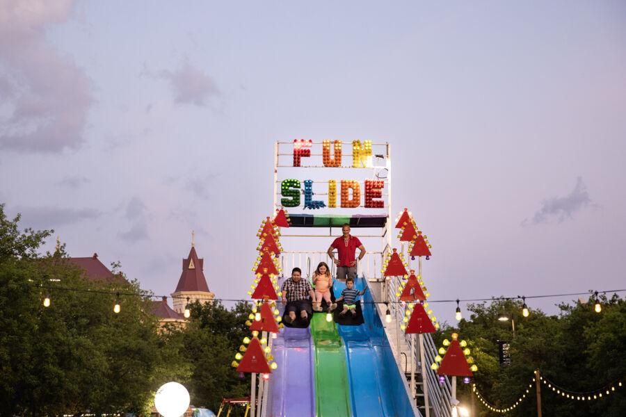 Students have fun going down a carnival slide during Hillfest