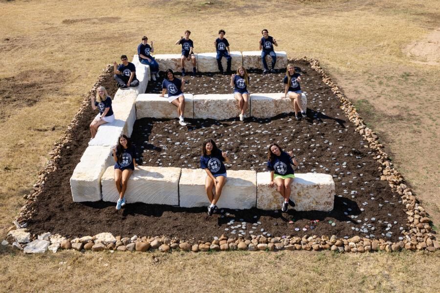 Students posing for a photo at The Big E structure on campus.