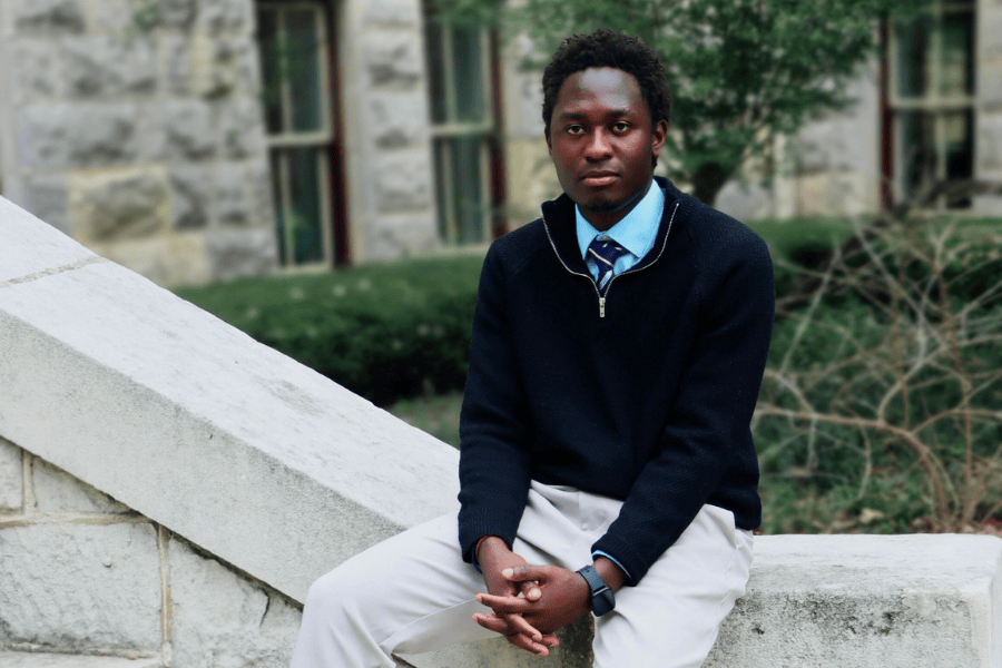 Current Student Samuel Muwanika poses in front of Main Building
