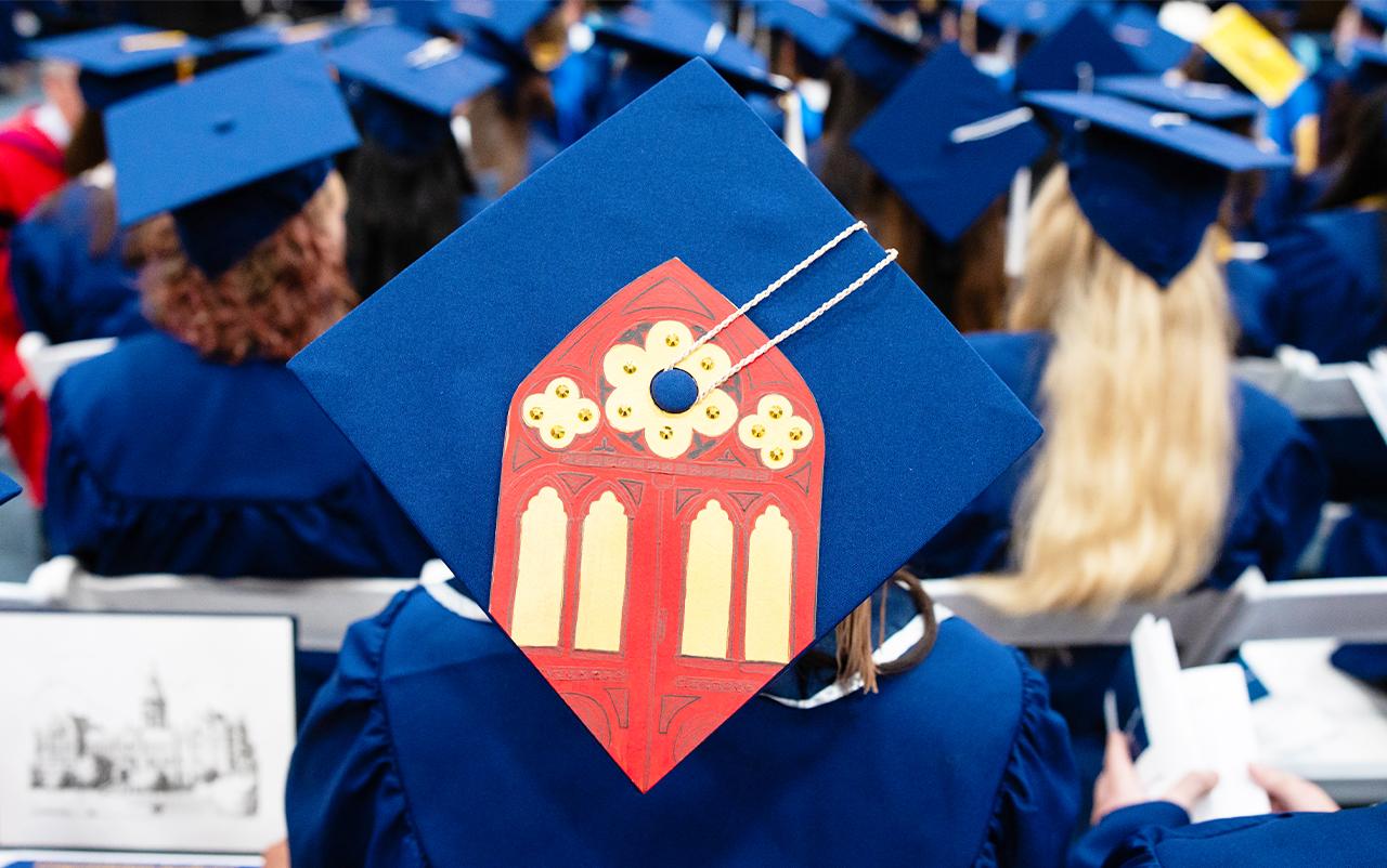 Close up of a graduating senior's cap decorated with an image of Main Building.