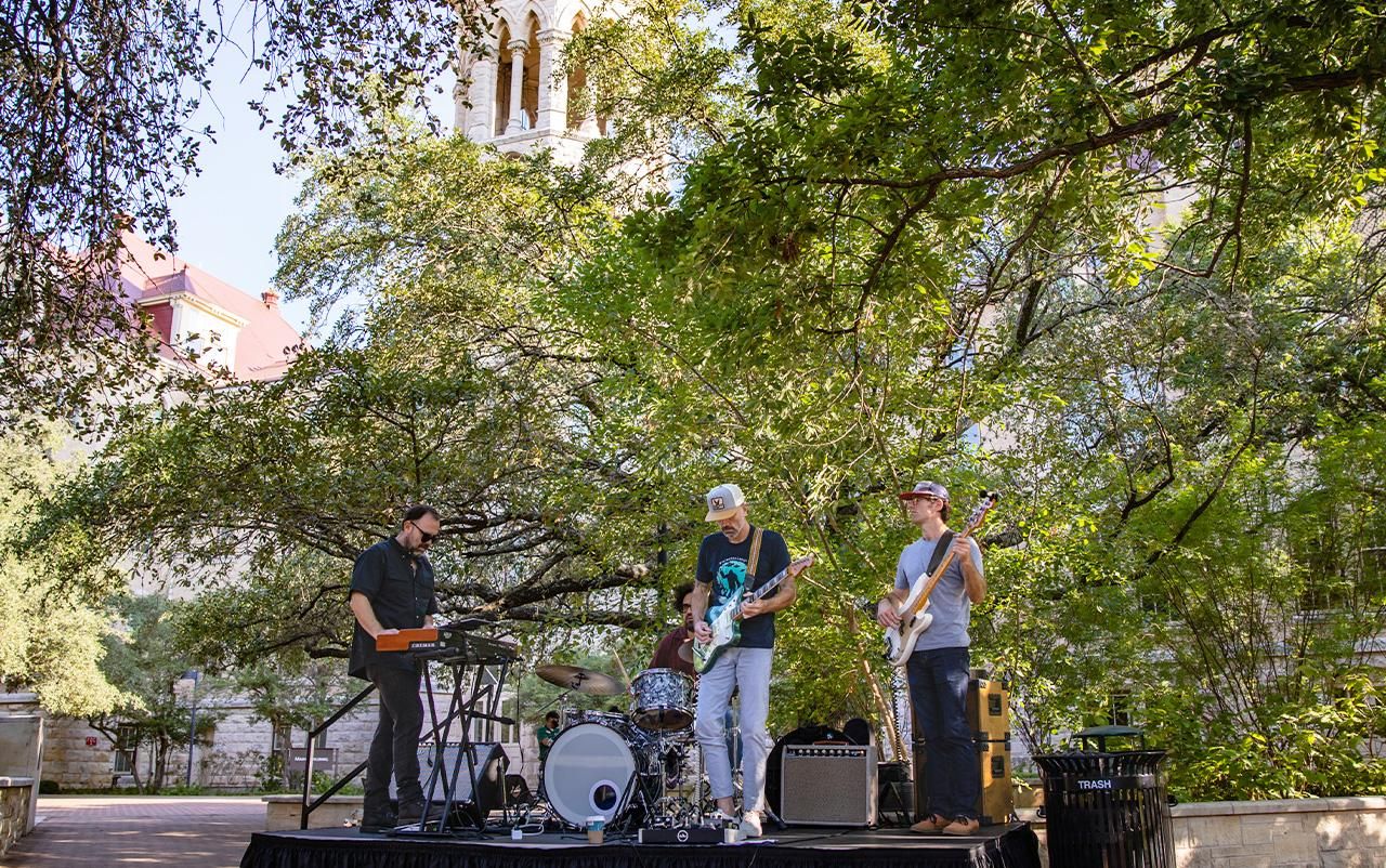 Band playing music on stage in front of Main Building.