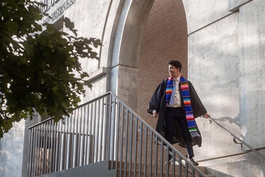 Alumnus Marco Martinez poses on the steps of the Bill Munday School of Business.